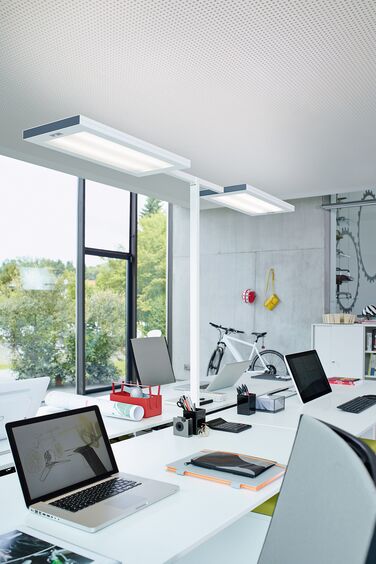 Moderne Bürobeleuchtung zwischen zwei Arbeitsplätzen